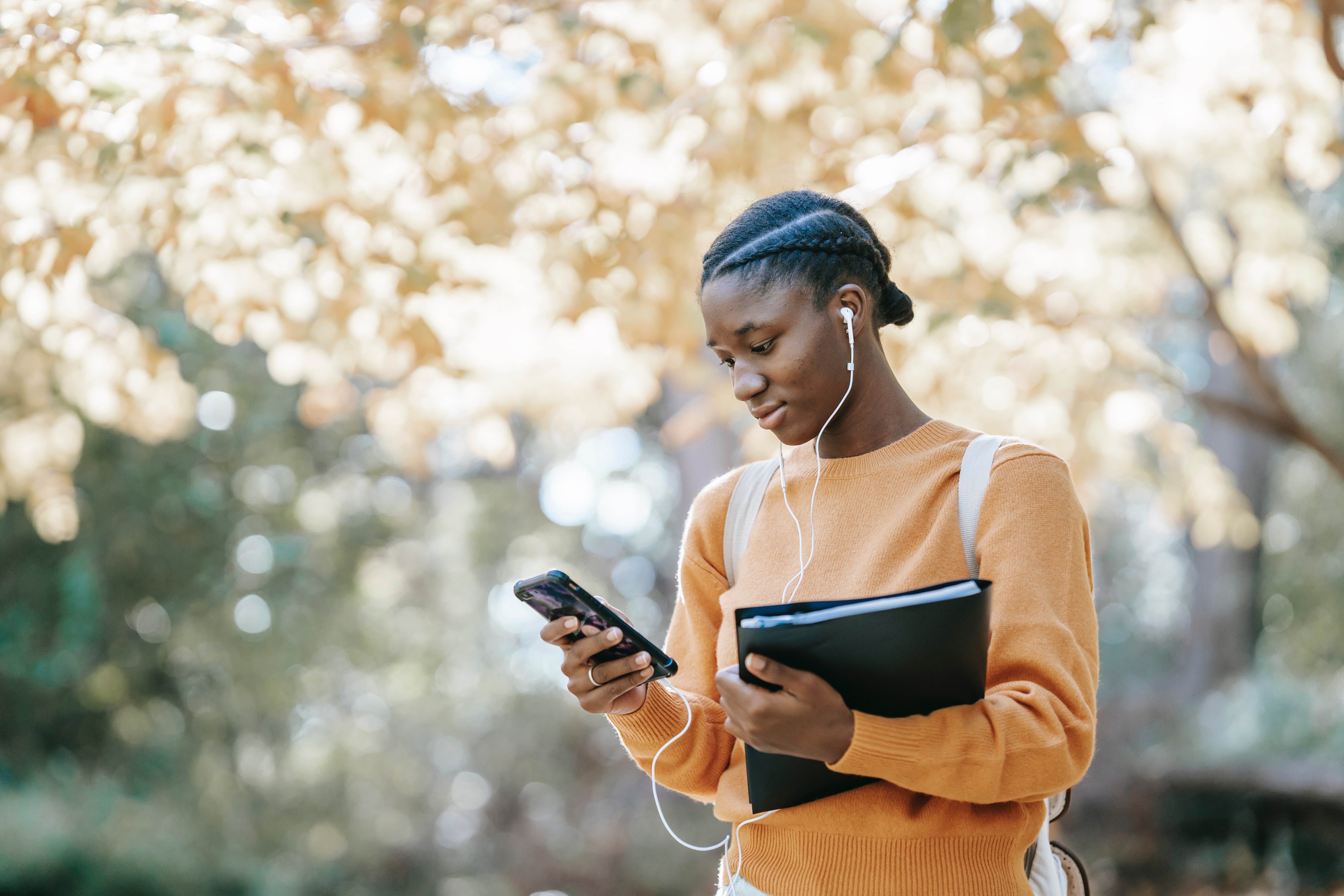 Photo by Charlotte May: Pexels black-student-listening-to-music-using-smartphone-in-park-5965930