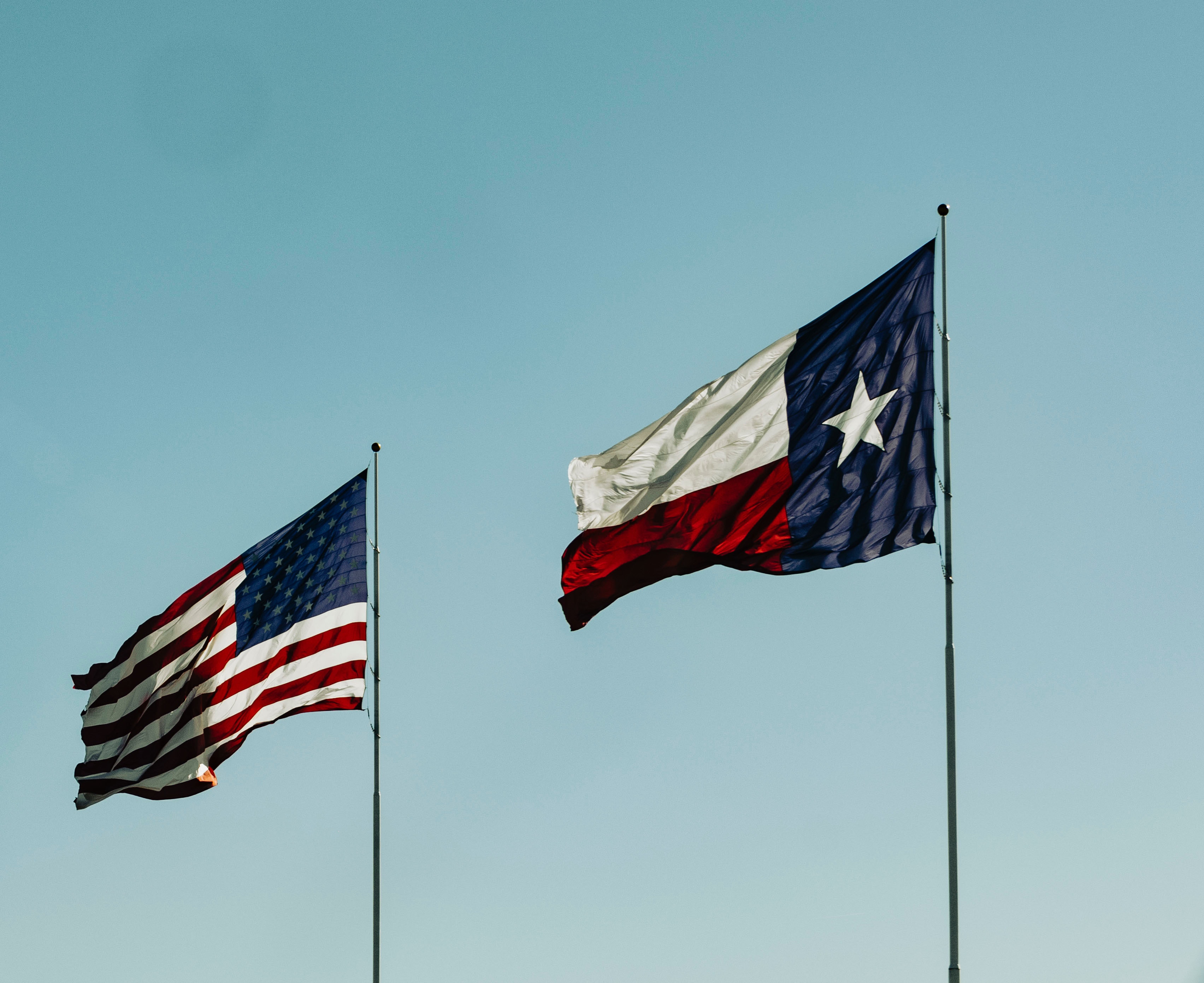 Photo by Talena Reese pexels photo american-flag-and-flag-of-texas-under-blue-sky-10471017